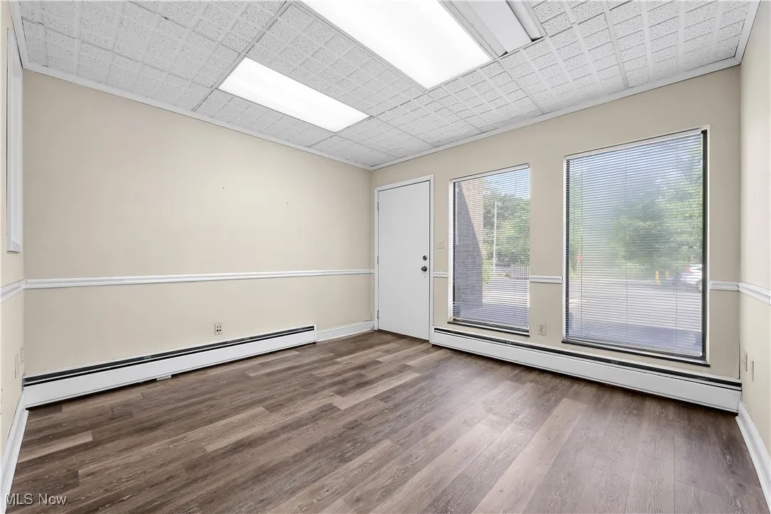 Spare room featuring a baseboard radiator and wood finished floors