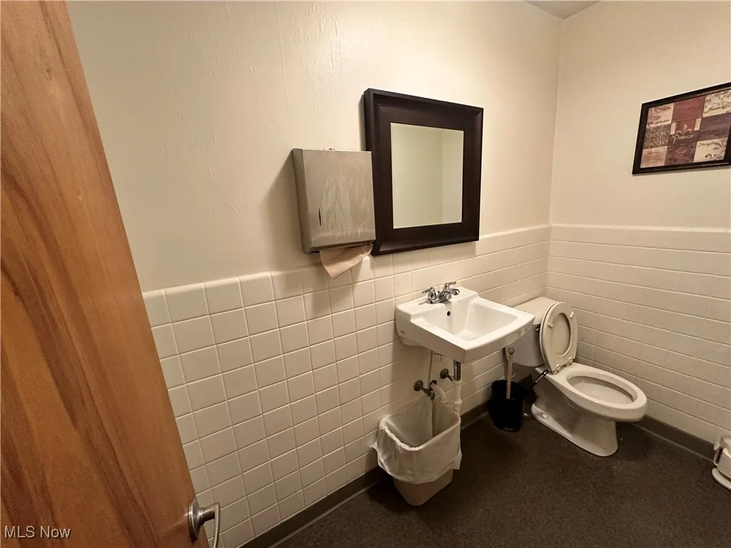 Bathroom featuring a wainscoted wall and tile walls