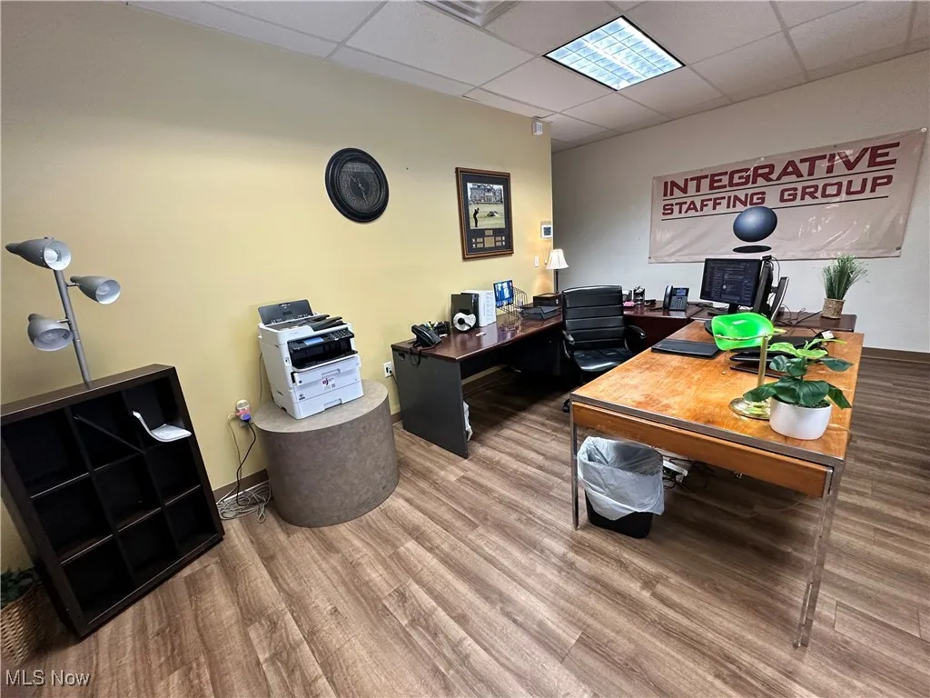 Office area with wood finished floors and a paneled ceiling
