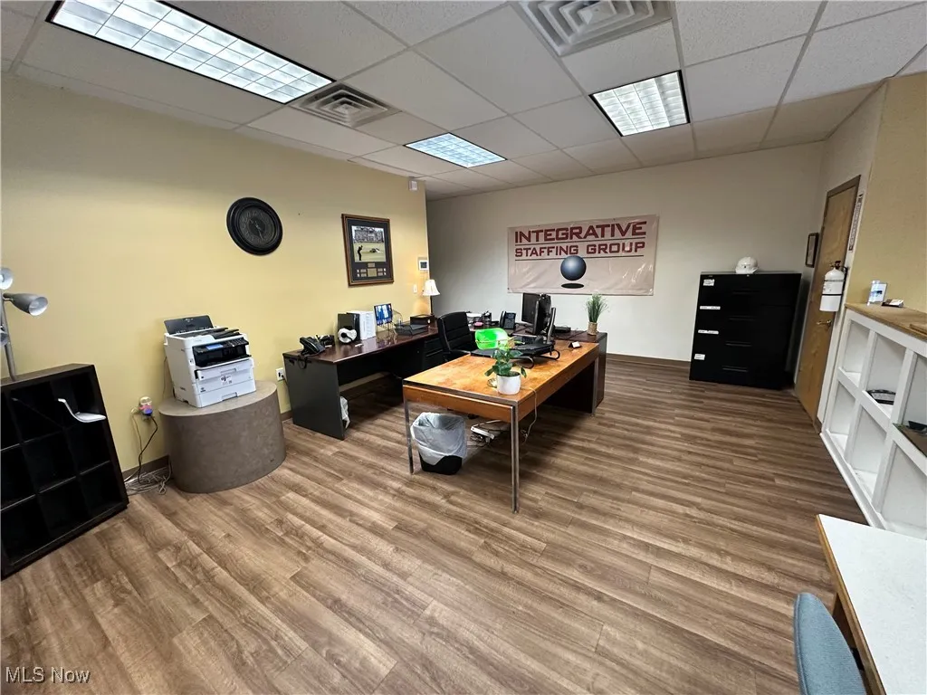 Office area featuring a drop ceiling and wood finished floors