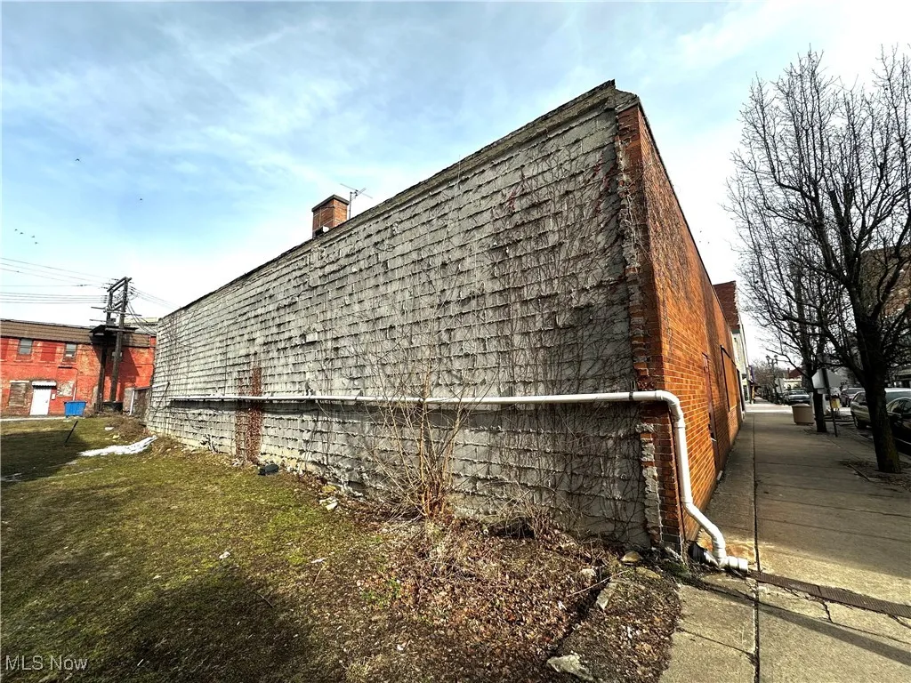 View of home's exterior with a chimney and a yard