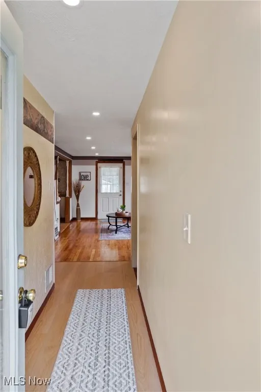 Hallway featuring visible vents, recessed lighting, light wood-style flooring, and baseboards