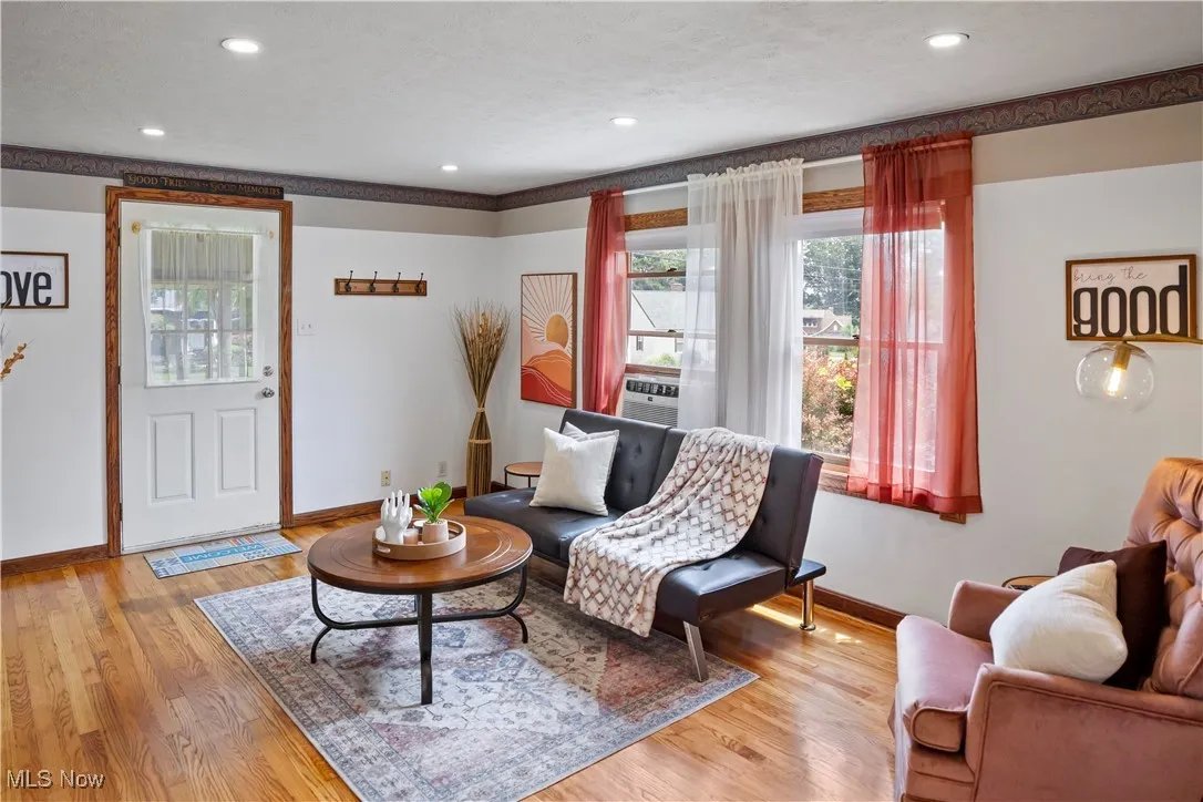 Living area featuring cooling unit, recessed lighting, a textured ceiling, light wood-type flooring, and baseboards