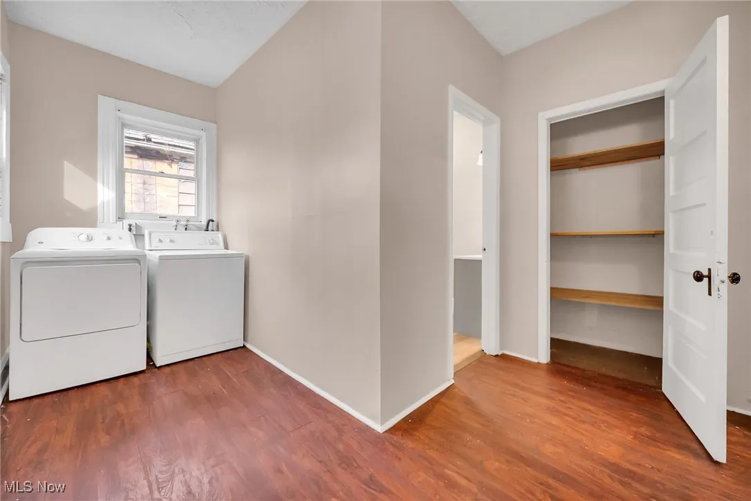 Washroom with laundry area, independent washer and dryer, baseboards, and wood finished floors