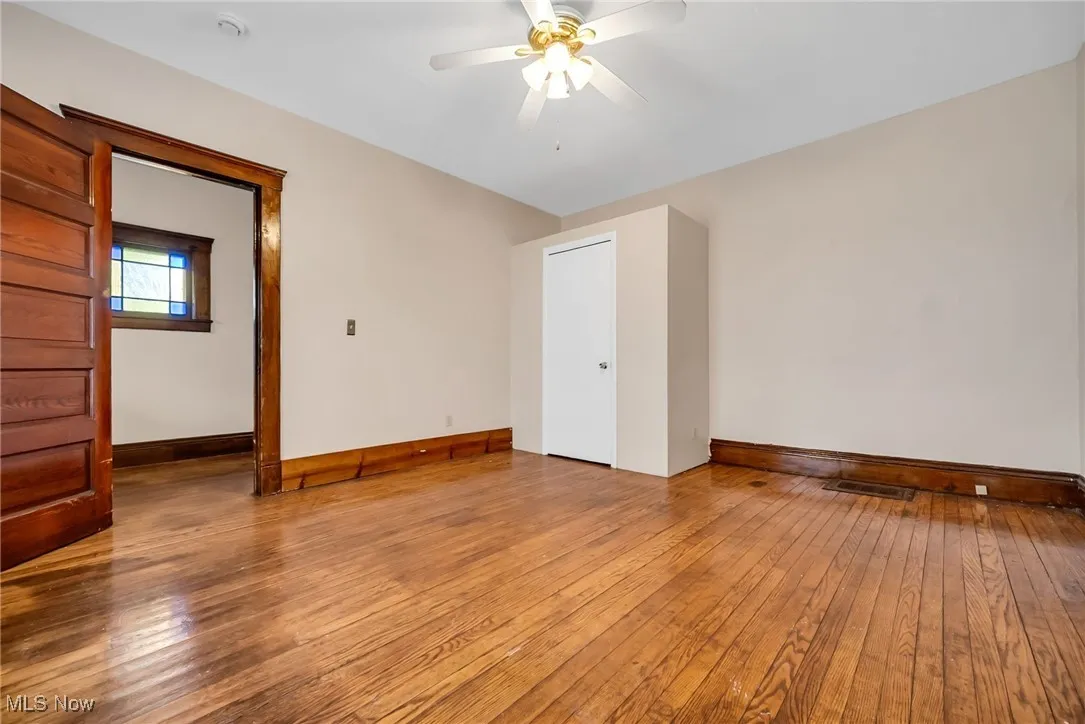 Spare room with visible vents, a ceiling fan, light wood-style flooring, and baseboards