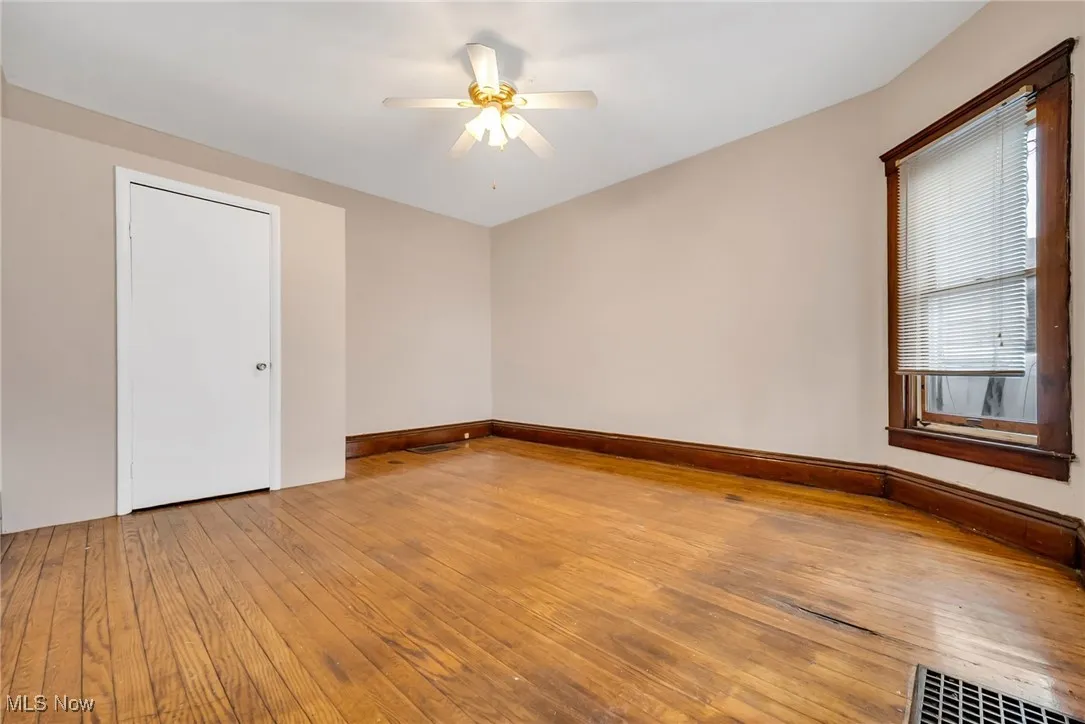 Spare room featuring ceiling fan, visible vents, baseboards, and hardwood / wood-style floors