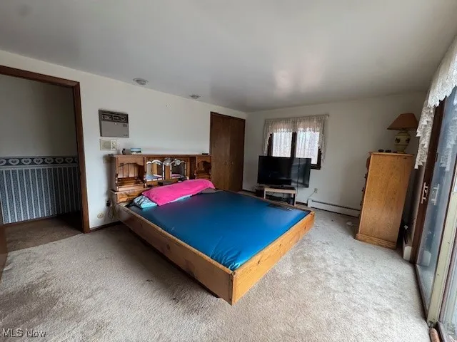 Carpeted bedroom with a baseboard radiator