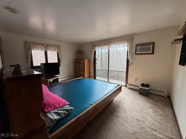 Game room with baseboards, a wall mounted air conditioner, carpet, baseboard heating, and a baseboard heating unit