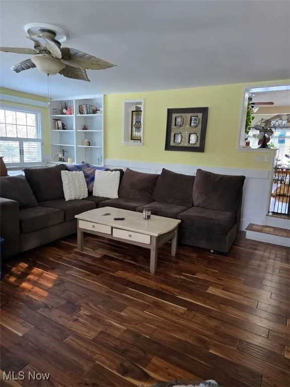 Living room with dark wood-style floors and ceiling fan