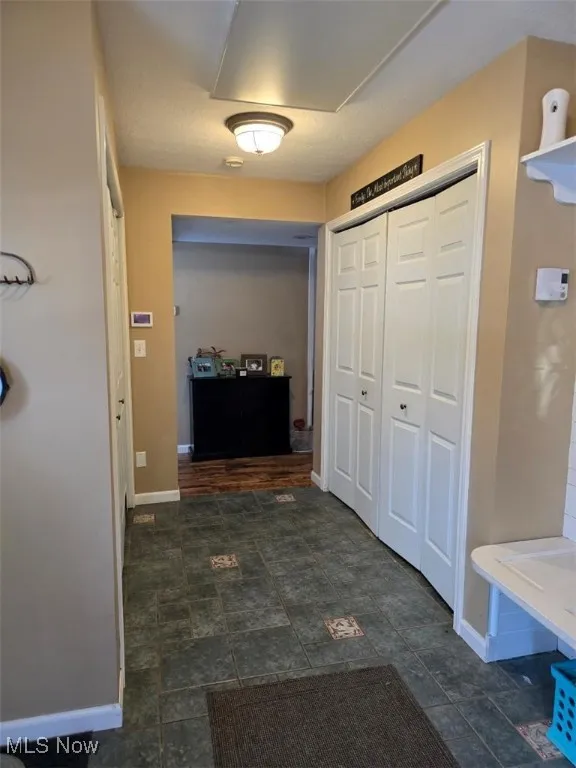 Hallway with stone finish flooring and baseboards
