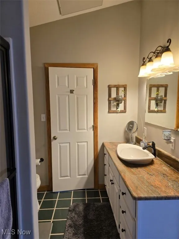 Bathroom featuring tile patterned flooring, vanity, and toilet