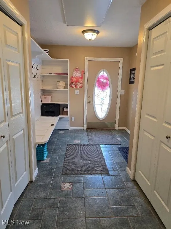Mudroom with stone tile floors and baseboards