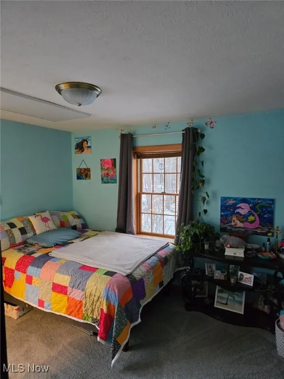 Bedroom with carpet and a textured ceiling
