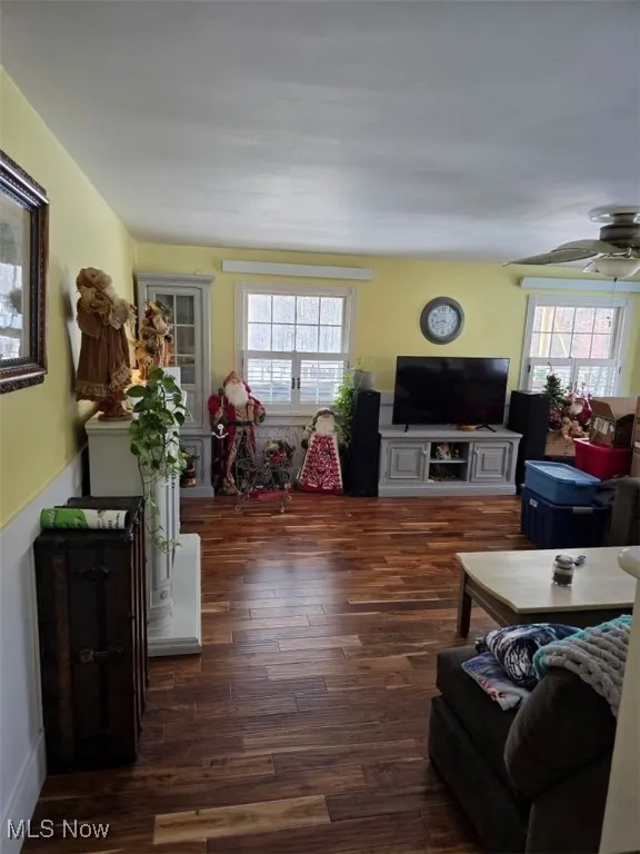 Living room with ceiling fan, plenty of natural light, and wood finished floors