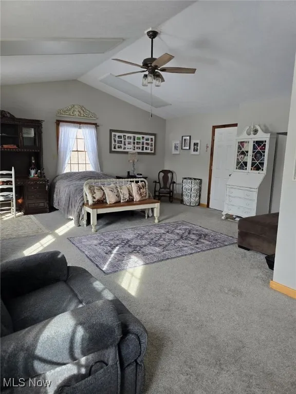 Living room with carpet, vaulted ceiling, and a ceiling fan