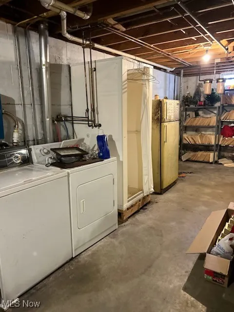 Unfinished basement with independent washer and dryer and freestanding refrigerator