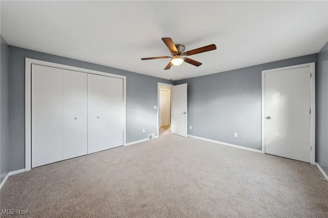 Unfurnished bedroom featuring baseboards, visible vents, ceiling fan, carpet floors, and a closet