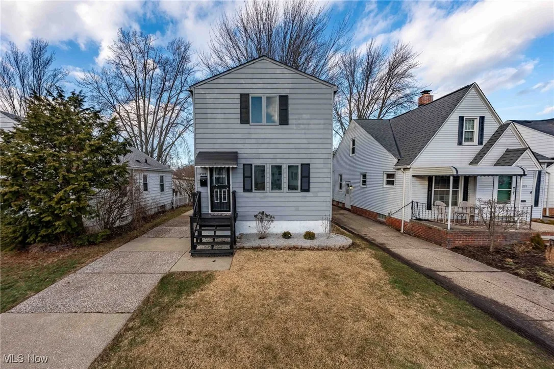 Traditional-style house with a front yard and covered porch