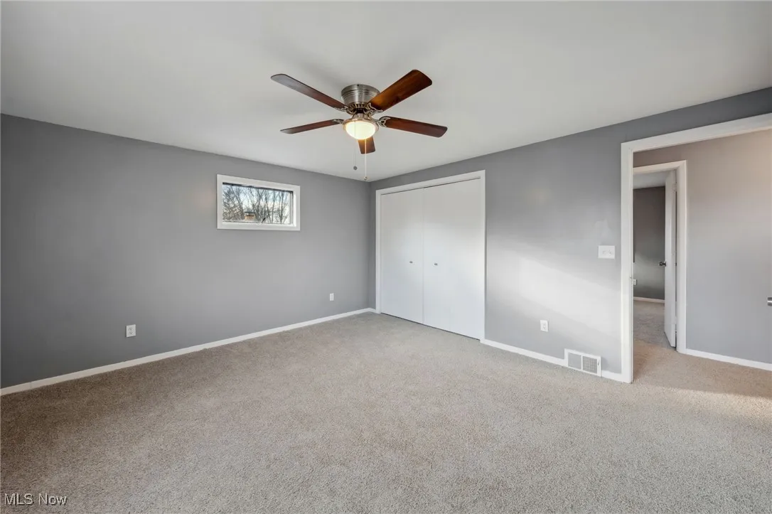 Unfurnished bedroom with carpet, a closet, visible vents, a ceiling fan, and baseboards