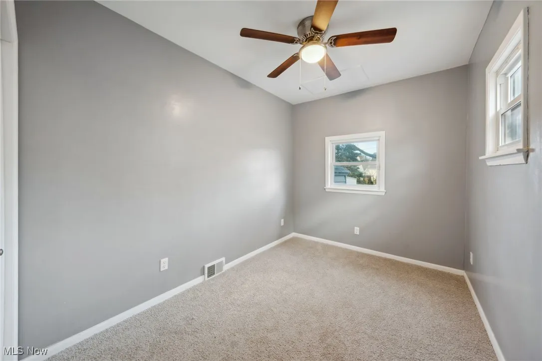 Empty room featuring baseboards, visible vents, ceiling fan, and carpet flooring
