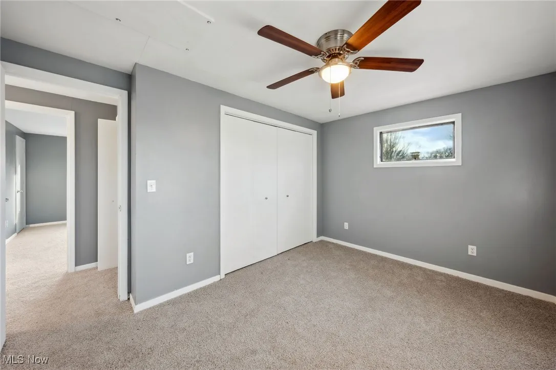 Unfurnished bedroom with carpet floors, a closet, ceiling fan, and baseboards