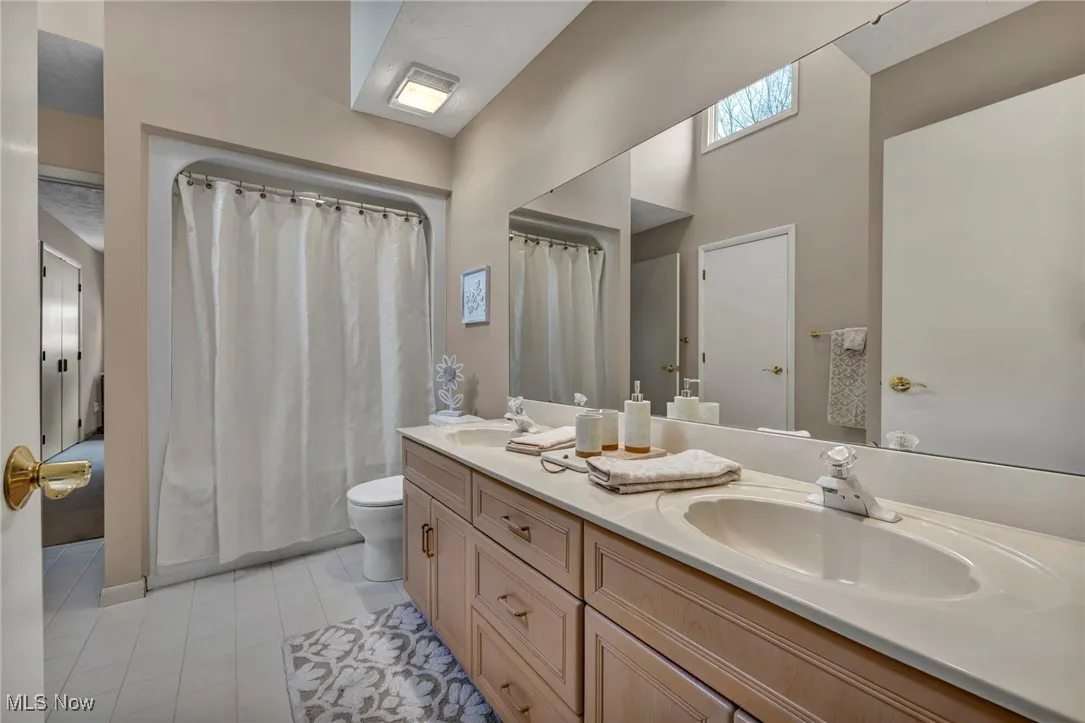 Upstairs Jack and Jill bathroom with double sink and tub and two linen closets.