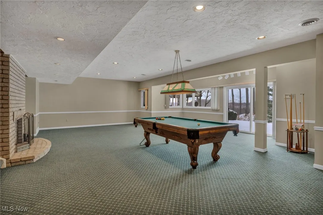 Another view of Lower Level family room with sliding glass doors to large patio with stairs to deck above.