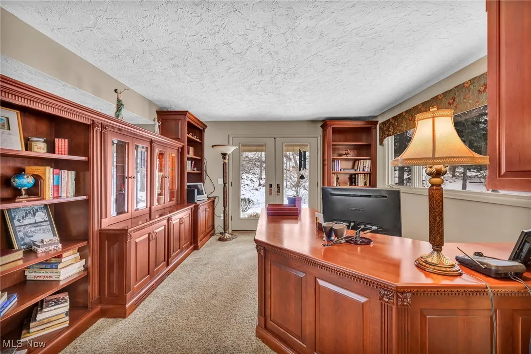 Library with French Doors to covered brick patio, room previously used as Formal Living room.  Carpet placed around furniture, Once furniture removed, new carpet to be installed.