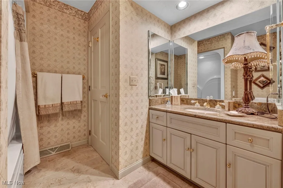 Travertine Floors in first floor full bath next to first floor bedroom.