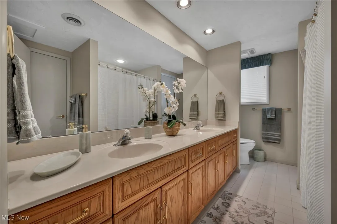 Lower Level bathroom features double sink, tub and linen closet. Door to large bedroom.