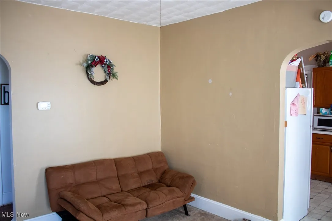 Living area with baseboards and arched walkways