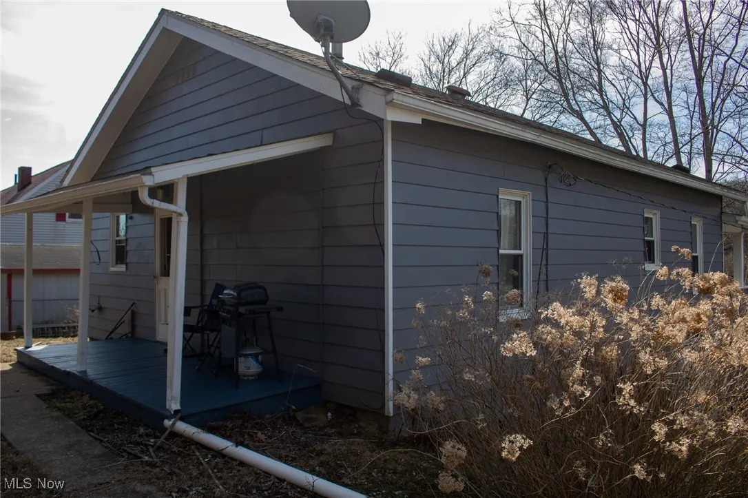 View of property exterior featuring a wooden deck