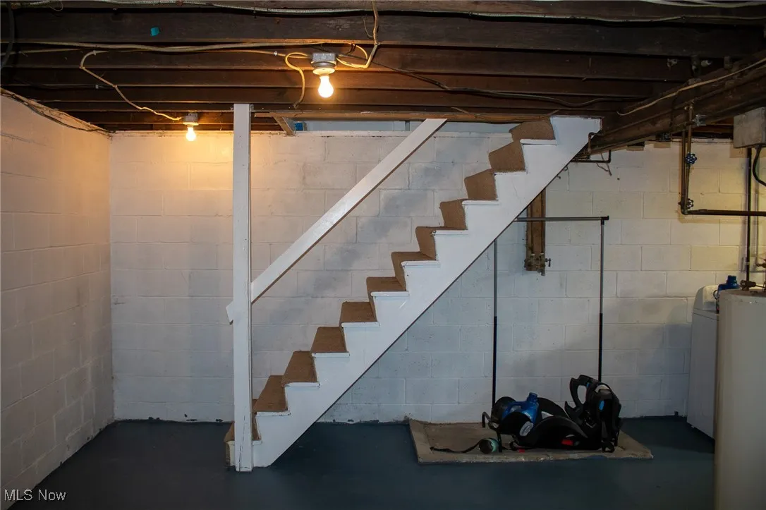 Unfinished below grade area featuring stairway