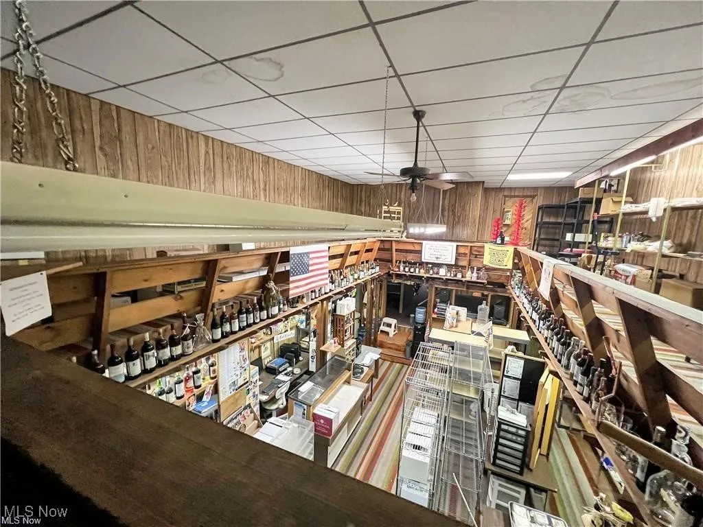 Wine room with wooden walls and a drop ceiling