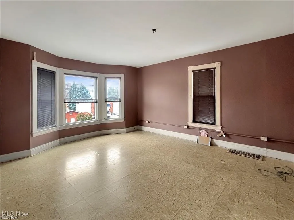 Unfurnished room with tile patterned floors, visible vents, and baseboards