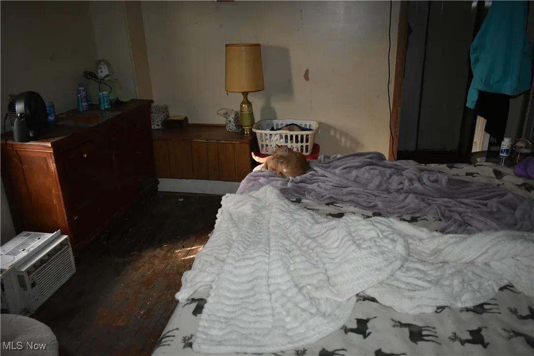 Bedroom featuring heating unit and dark wood finished floors