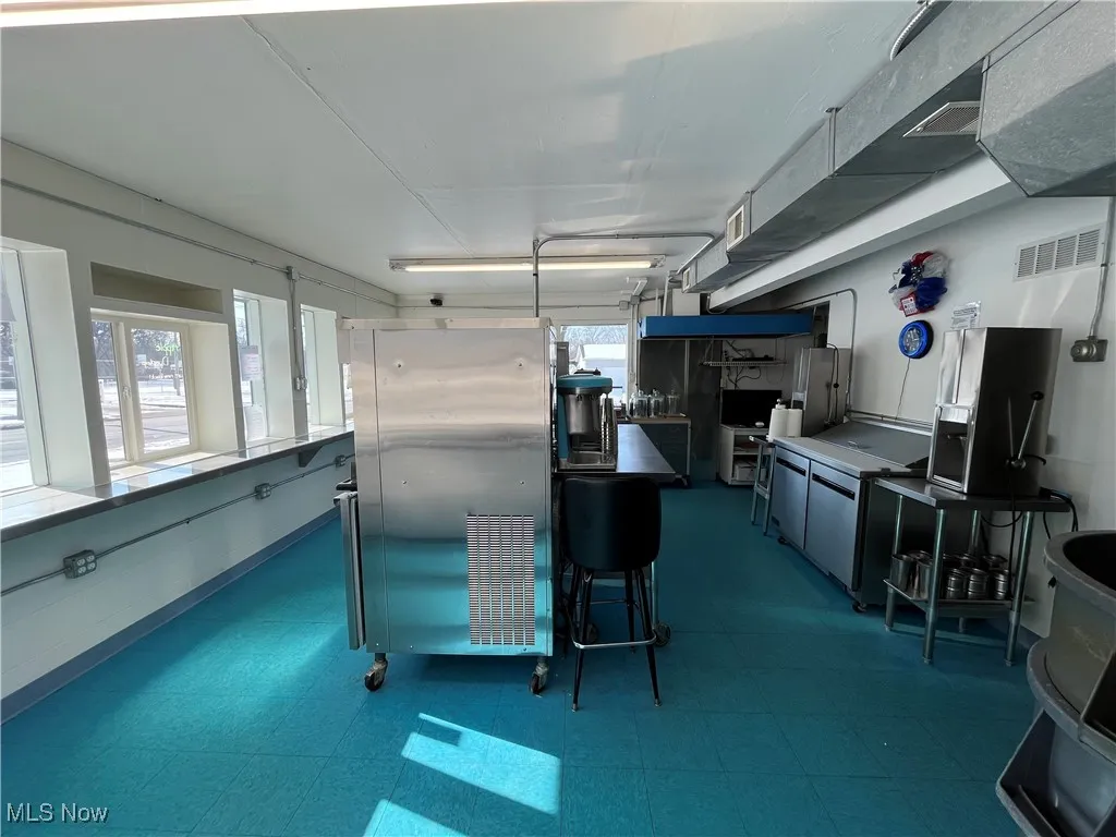 Kitchen with freestanding refrigerator, visible vents, and tile patterned floors
