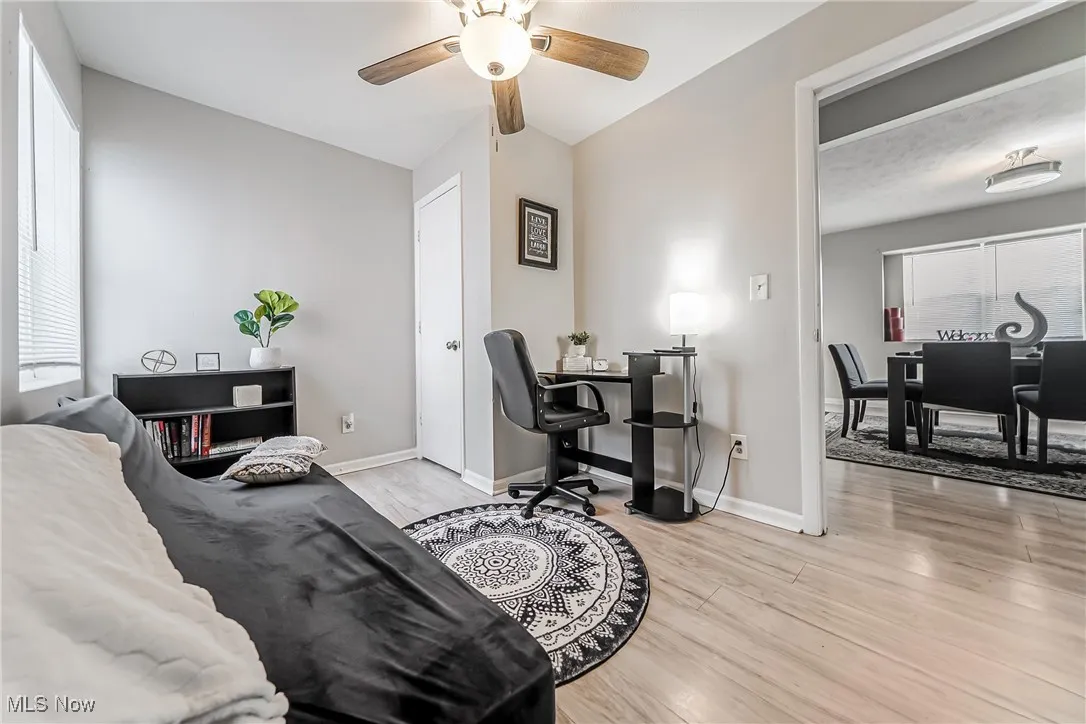 Bedroom with light wood-style floors, baseboards, and a ceiling fan
