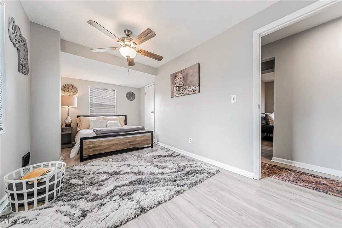 Bedroom with wood finished floors, a ceiling fan, and baseboards