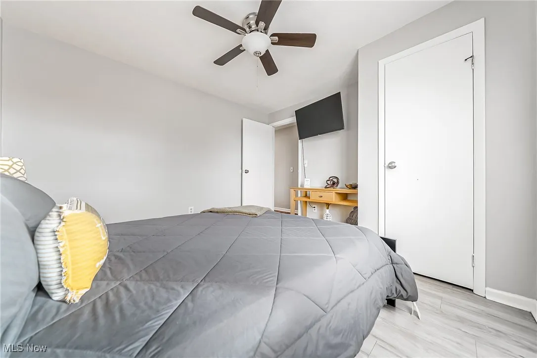 Bedroom with ceiling fan, baseboards, and light wood-style flooring