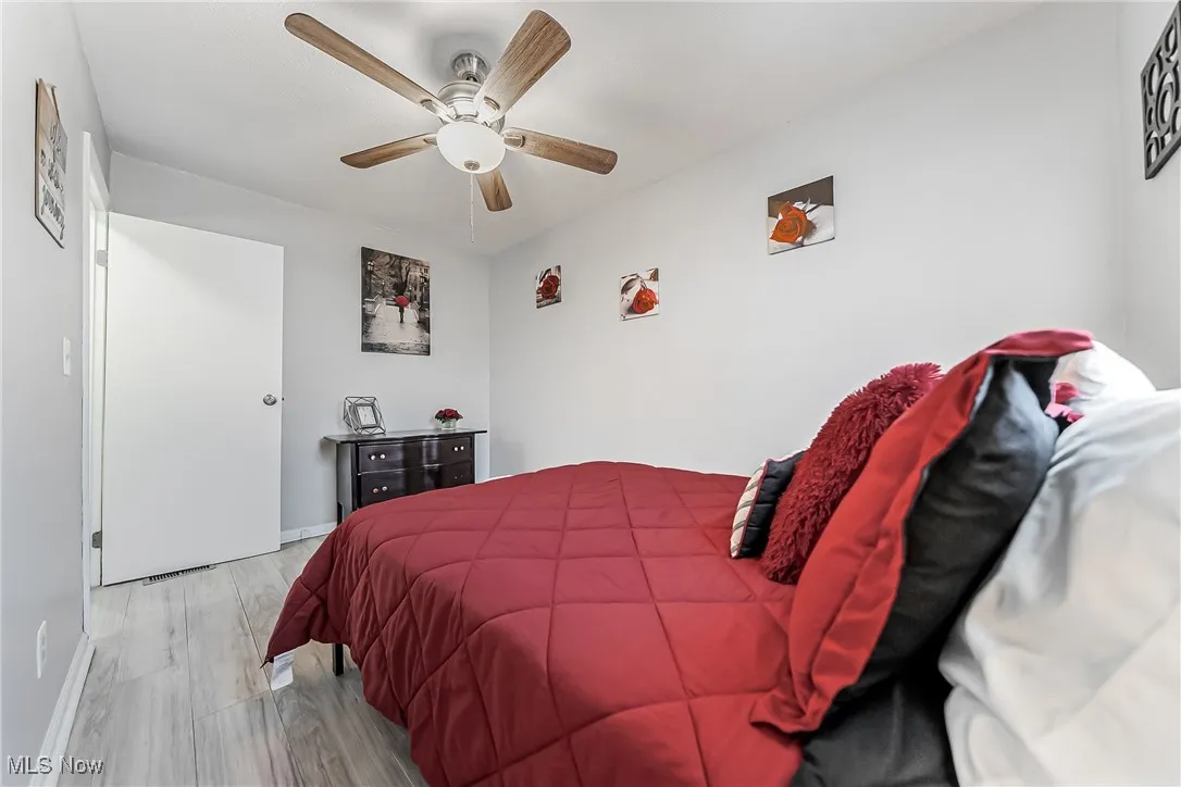 Bedroom featuring a ceiling fan, light wood-type flooring, and baseboards