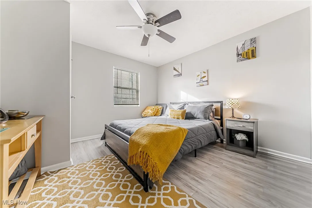 Bedroom with a ceiling fan, baseboards, and wood finished floors