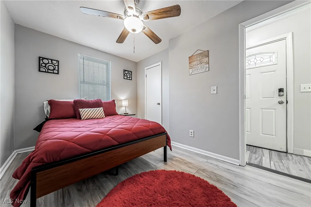 Bedroom featuring a ceiling fan, light wood-type flooring, and baseboards