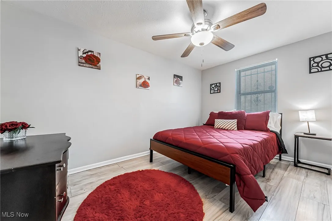Bedroom featuring baseboards, ceiling fan, and light wood finished floors