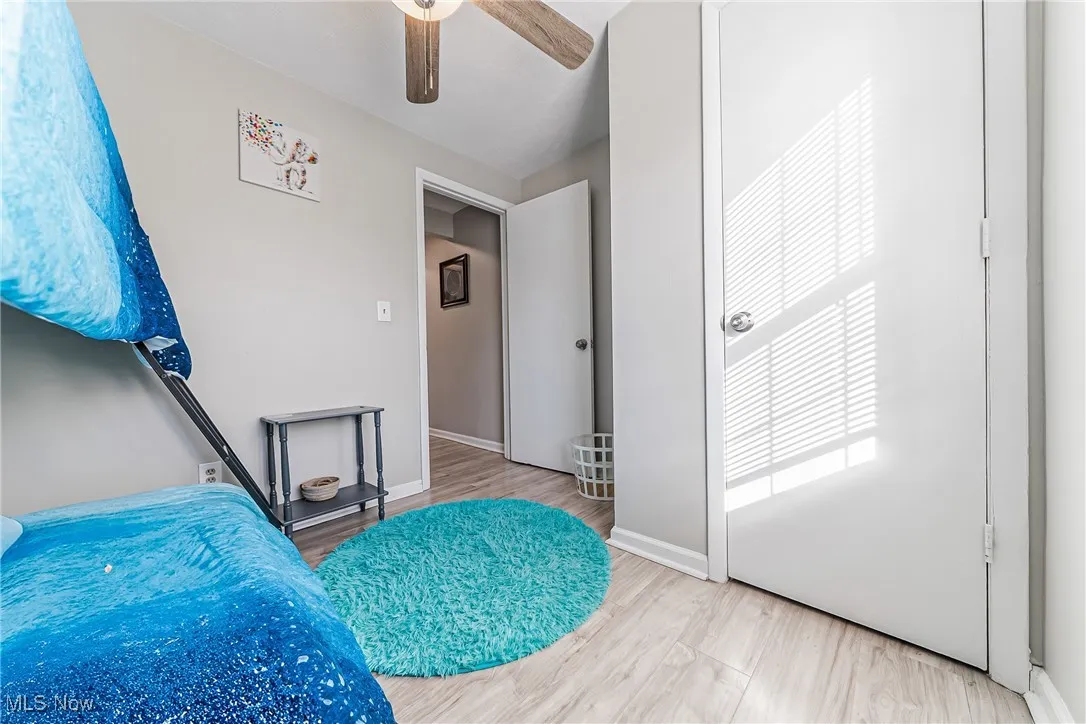 Bedroom featuring a ceiling fan, baseboards, and wood finished floors