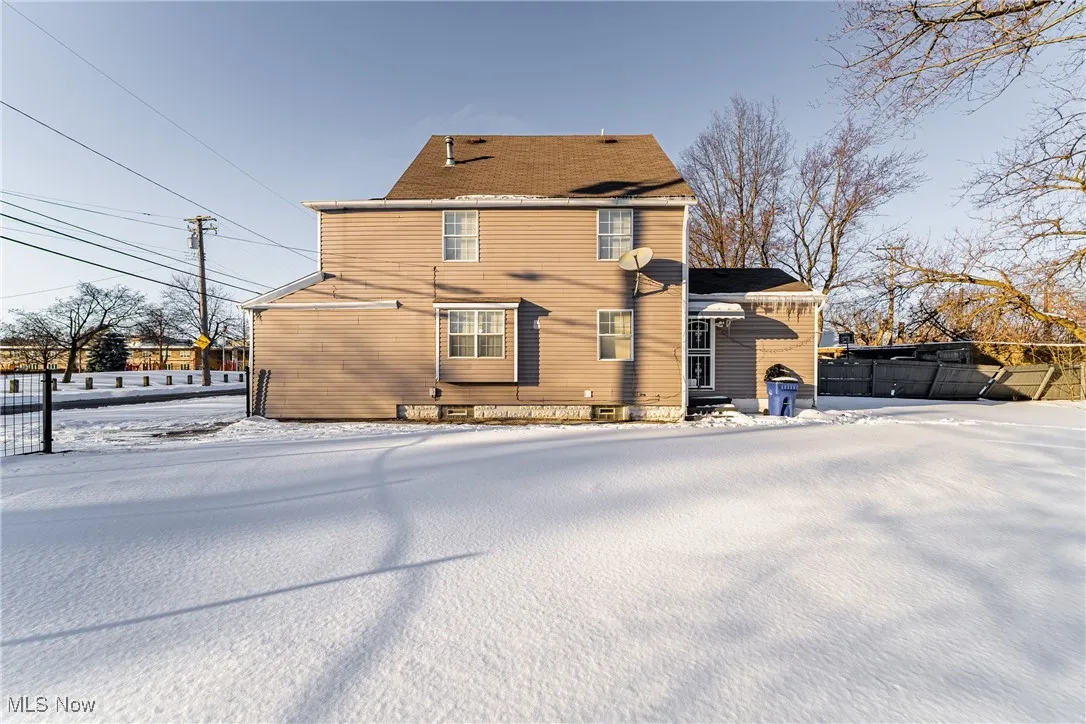 Snow covered house with fence