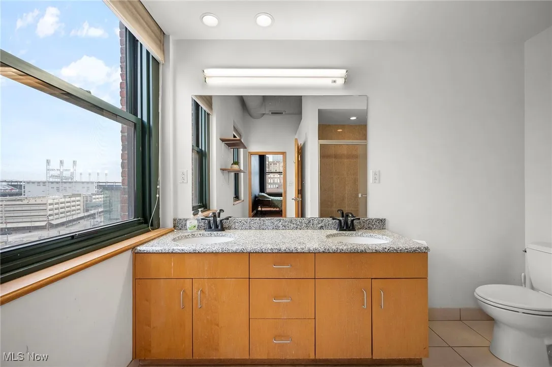 Full bathroom with toilet, tile patterned flooring, a sink, and a shower stall
