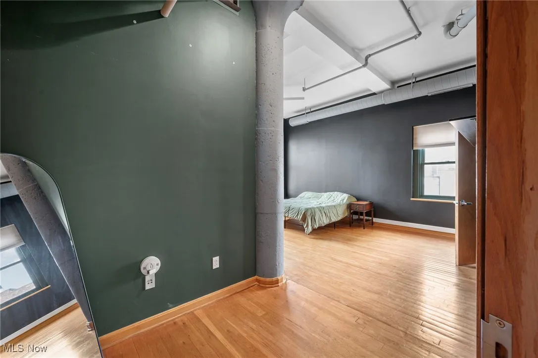 Bedroom with wood finished floors and baseboards