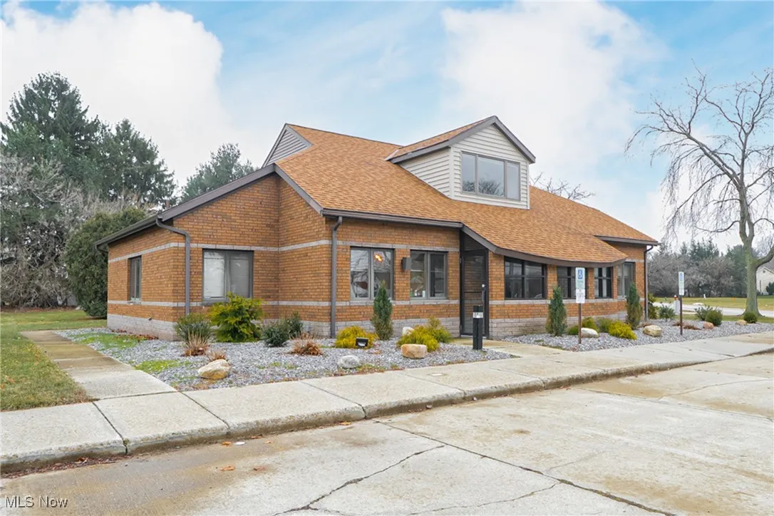 View of front of home featuring brick siding and a shingled roof