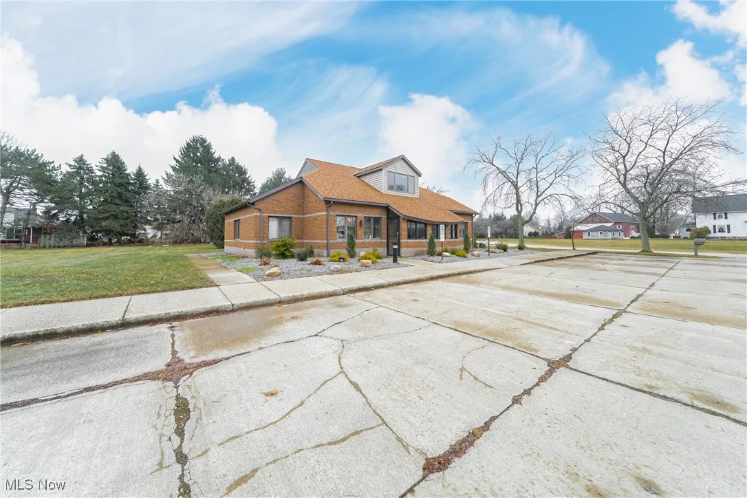 View of front of property featuring brick siding and a front lawn
